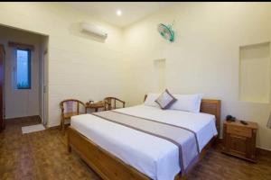 une chambre avec un grand lit blanc et une fenêtre dans l'établissement Globiquex hotels, Phu quoc, à Duong Dong 4 autres photos