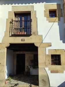 a stone building with a balcony and a door at Casona de Gómez y Terán in Renedo