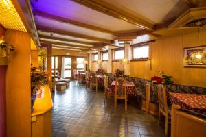 a restaurant with tables and chairs in a room at Hotel Trentino in Folgaria