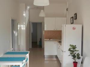 a kitchen with white cabinets and a white refrigerator at Apartments Nautica II in Novigrad Istria