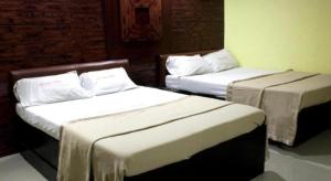 two beds in a room with two beds sidx sidx sidx at Bermuda Hotel in Manila