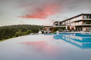 a large swimming pool in front of a building at Odyssey ClubHotel Wellness & SPA Adults Only in Kielce