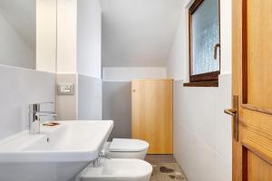 une salle de bains avec un lavabo blanc et des toilettes dans l'établissement Casa Serena, à Cavalese 29 autres photos
