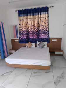 ein Schlafzimmer mit einem Bett mit einem blauen Vorhang in der Unterkunft Eco Eden Homestay in Kalpatta