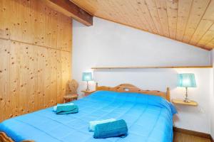 une chambre avec un lit bleu avec deux sacs bleus dessus dans l'établissement Casa Serena, à Cavalese