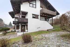 une maison blanche avec un toit de chaume dans l'établissement Casa Serena, à Cavalese