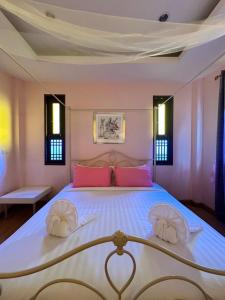 a bedroom with a large bed with pink pillows at Excellence Pool Villa in Na Jomtien