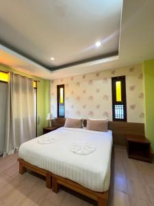 a bedroom with a large white bed and windows at Excellence Pool Villa in Na Jomtien
