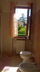 ein Bad mit einem WC und einem Fenster in der Unterkunft Apartment Via Vittoria in Bastia Umbra
