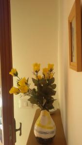 eine Vase voller gelber Blumen auf einem Tisch in der Unterkunft Apartment Via Vittoria in Bastia Umbra
