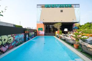 een zwembad voor een gebouw met graffiti bij The Quartier Hotel Phromphong - Thonglor in Bangkok