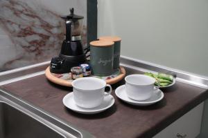 two cups and saucers on a counter with a coffee maker at Sweet Studios Kavala in Kavála