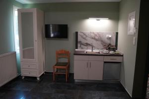 a small kitchen with a sink and a chair at Sweet Studios Kavala in Kavála +17 photos