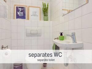 une salle de bain blanche avec un lavabo et des toilettes dans l'établissement Altstadt Suite mit Parkplatz, à Cobourg 18 autres photos