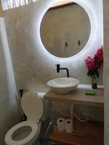 a bathroom with a sink and a toilet and a mirror at Casa Bella Guriú in Guriú +8 photos