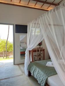 a bedroom with a bed with a mosquito net at Casa Bella Guriú in Guriú