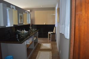 a bathroom with a sink and a bath room at Vila Pedra Mar in Praia Vermelha
