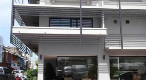a white building with a car in a window at Iroom Hotel in Surat Thani