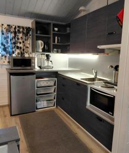 a kitchen with gray cabinets and a sink at Lomakylä Atimo in Alakitka