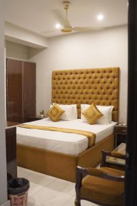 a bedroom with a large bed with a large headboard at Hotel Shanze Palace in Lahore