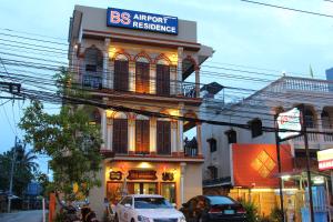 BS Airport at Phuket في شاطئ ناي يانغ: سيارة بيضاء متوقفة أمام مبنى