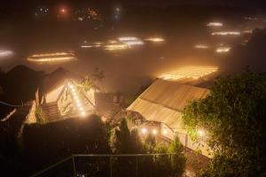 a misty night view of a house with lights at The LOOP Boutique Hotel & Café in Da Lat