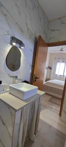 une salle de bains avec un lavabo blanc et un miroir dans l'établissement Villa Nour Kélibia, à Kelibia