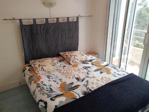 a bed with a black headboard with a flower pattern at Exceptionnelle vue front de mer avec accès direct plage in Saint Malo