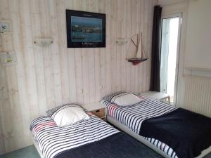 two beds in a room with a tv on the wall at Exceptionnelle vue front de mer avec accès direct plage in Saint Malo