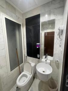 a bathroom with a white toilet and a sink at فندق أمل المشاعر in An Nikāshah +40 photos