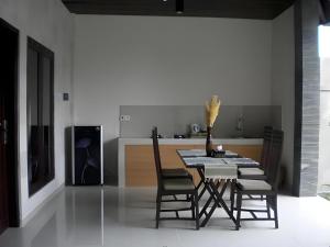 une salle à manger avec une table et des chaises et une cuisine dans l'établissement Evita Villas, à Sukawati