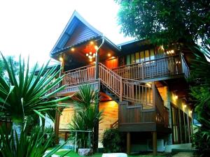ein Haus mit einer Treppe an der Seite in der Unterkunft Baan Saranrom in Amphawa
