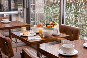 a wooden table with a bowl of fruit on it at Hôtel de la Comète in Paris
