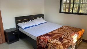 een kleine slaapkamer met een bed met een houten hoofdeinde bij Neevah Farm in Sehore