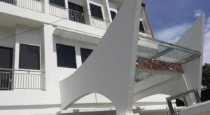 a white building with a staircase in front of it at OPRISS HOTEL in Parapat +3 photos