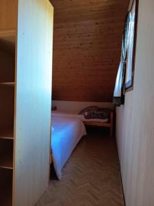 ein kleines Schlafzimmer mit einem Bett in einer Holzhütte in der Unterkunft Appartement 4, 5 couchages in Chabottes