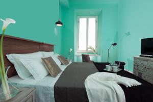 a bedroom with a large bed with blue walls at Daniele Manin Guesthouse in Rome