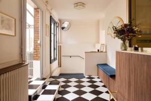 a hallway with a black and white checkered floor at Hôtel de la Comète in Paris +36 photos