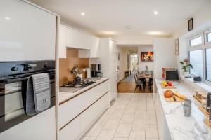 a large kitchen with white cabinets and a table at 5 Bed in Mumbles oc-l34618 in The Mumbles