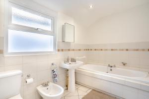 a white bathroom with a sink and a bath tub at 5 Bed in Mumbles oc-l34618 in The Mumbles +36 photos