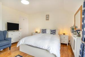 a white bedroom with a bed and a tv at 5 Bed in Mumbles oc-l34618 in The Mumbles