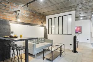 un salon avec un canapé et une table dans l'établissement Maisons Alfort 6 Luxurious little house with private garden and Jacuzzi, à Maisons-Alfort