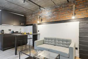 un salon avec un canapé et une table dans une cuisine dans l'établissement Maisons Alfort 6 Luxurious little house with private garden and Jacuzzi, à Maisons-Alfort