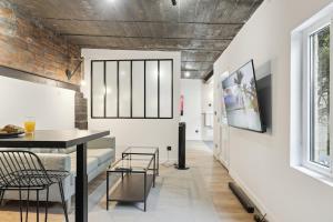 - un salon avec une table et des chaises ainsi qu'un mur en briques dans l'établissement Maisons Alfort 6 Luxurious little house with private garden and Jacuzzi, à Maisons-Alfort