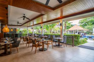 a restaurant with tables and chairs and a patio at Sunprime Kamala Beach in Kamala Beach
