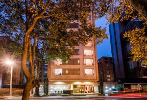 un edificio alto con un árbol delante de él en Hotel Cabrera Imperial By key 33, en Bogotá