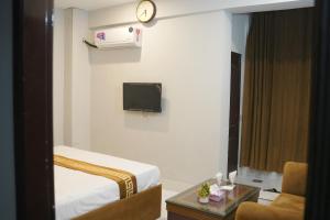 a hotel room with a bed and a clock on the wall at Hotel Shanze Palace in Lahore