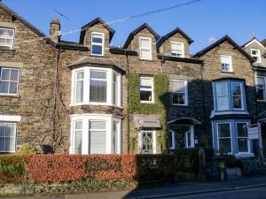 a brick house with white windows and ivy at Norwood House in Ambleside