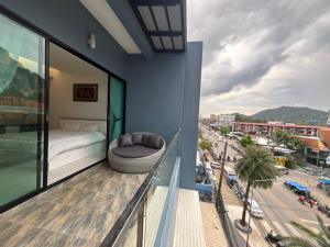 een balkon met een bed en uitzicht op de stad bij Phranang Place- SHA Extra in Ao Nang Beach