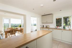 a kitchen with white cabinets and a dining room with a table at 3 Bed in Ampleforth oc-m34673 in Ampleforth